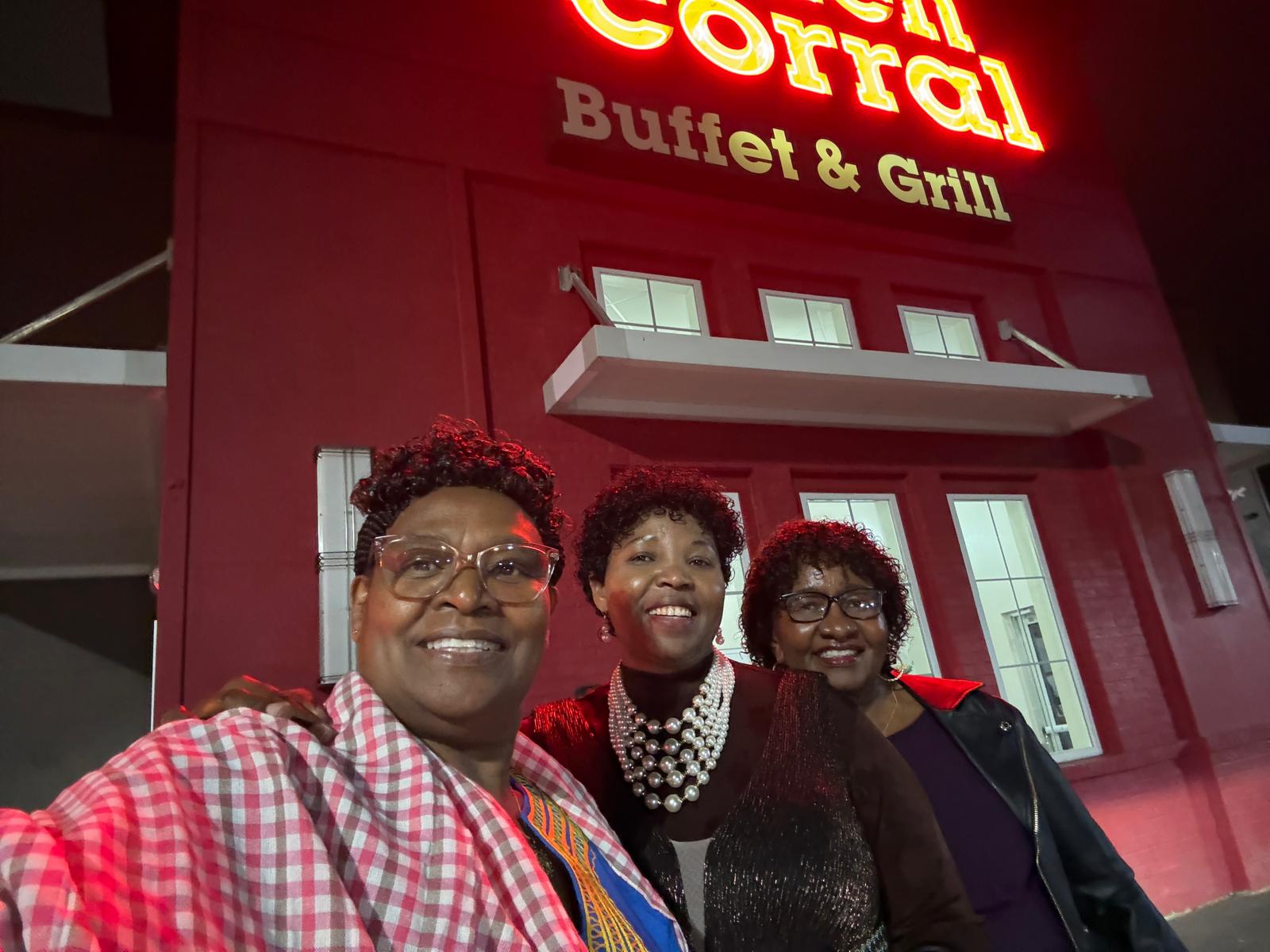 Three community members posing for an evening group selfie
