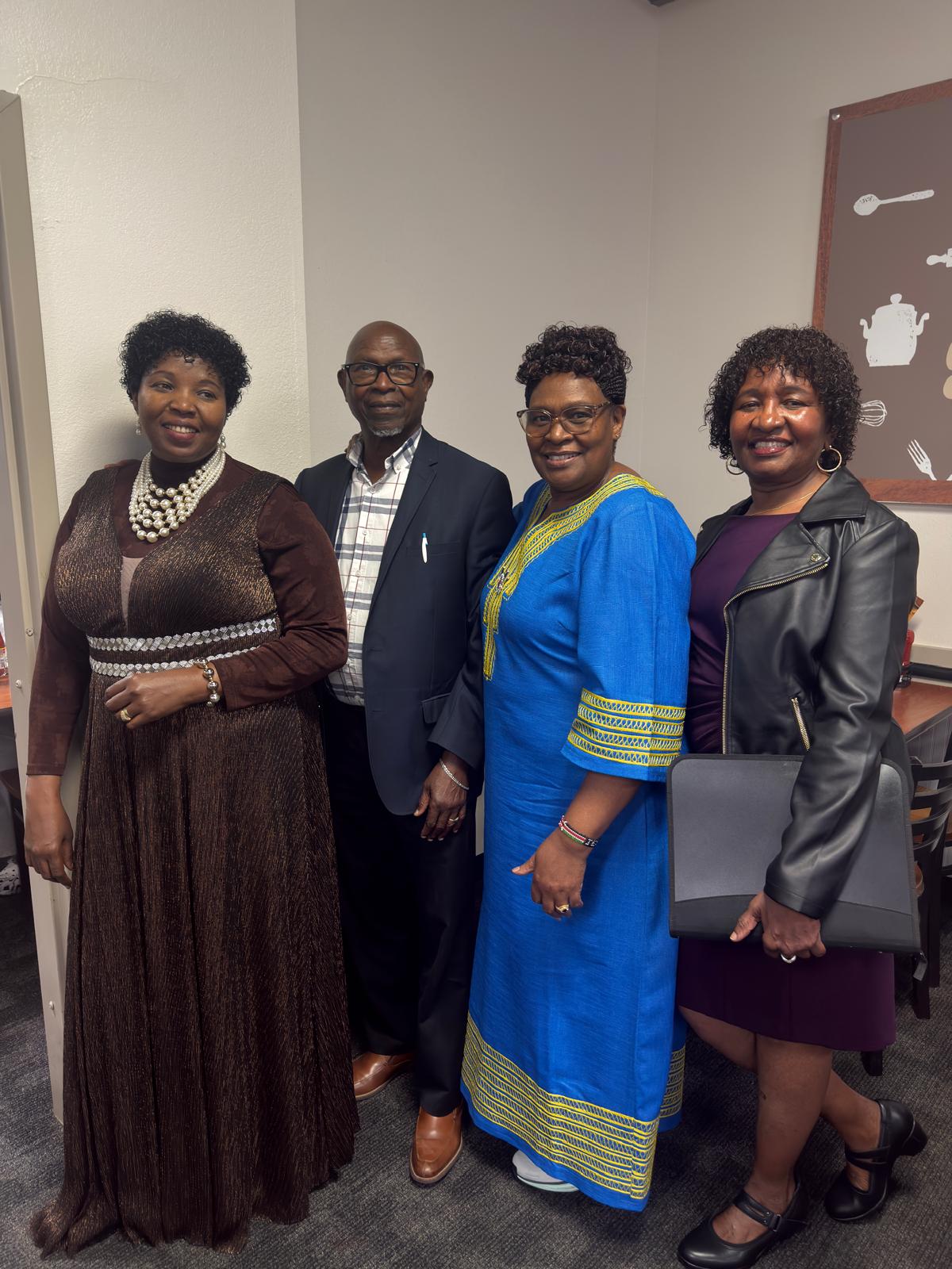 Four community members posing together at an indoor gathering