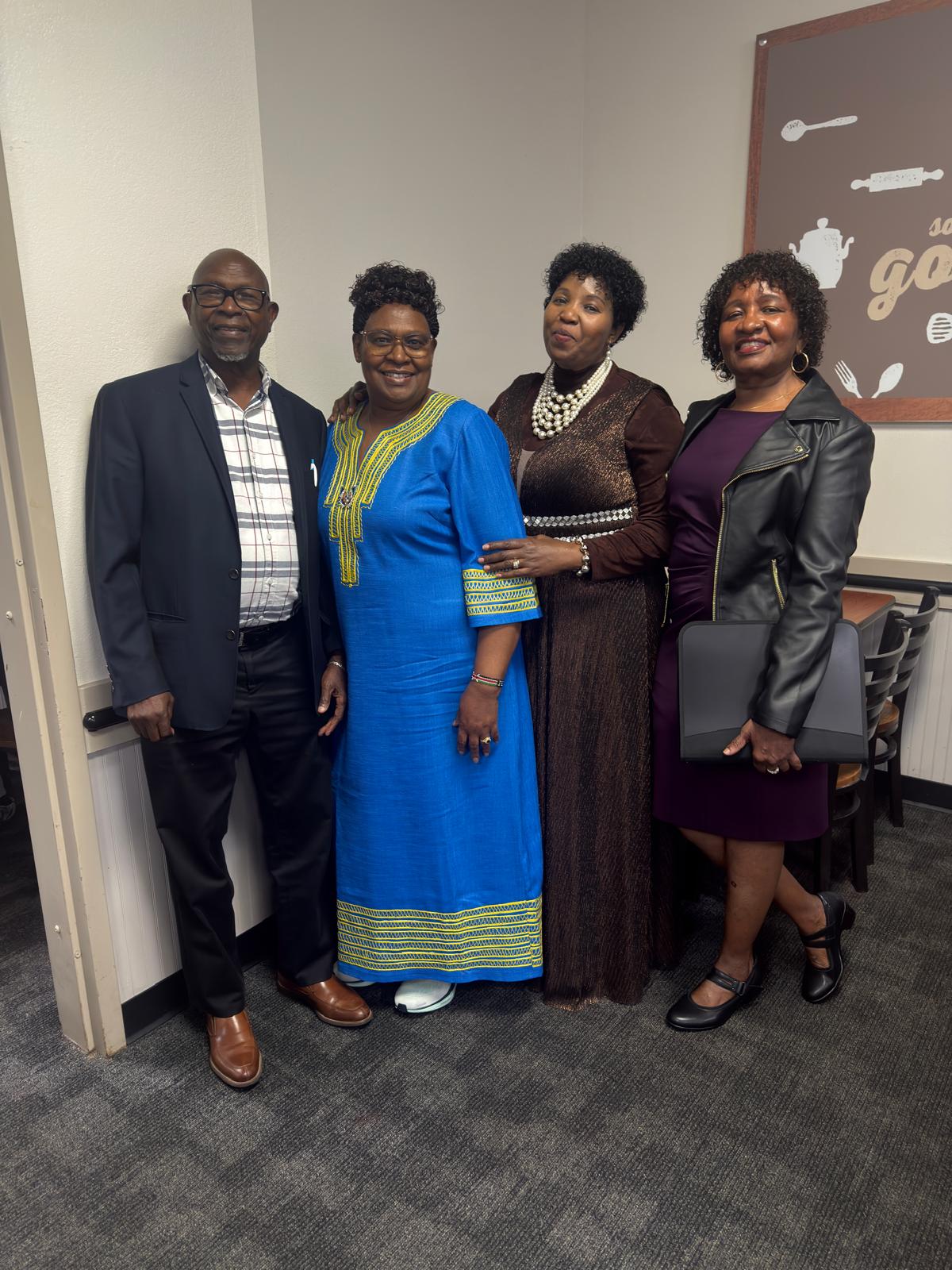 Four community members standing together for an indoor group photo