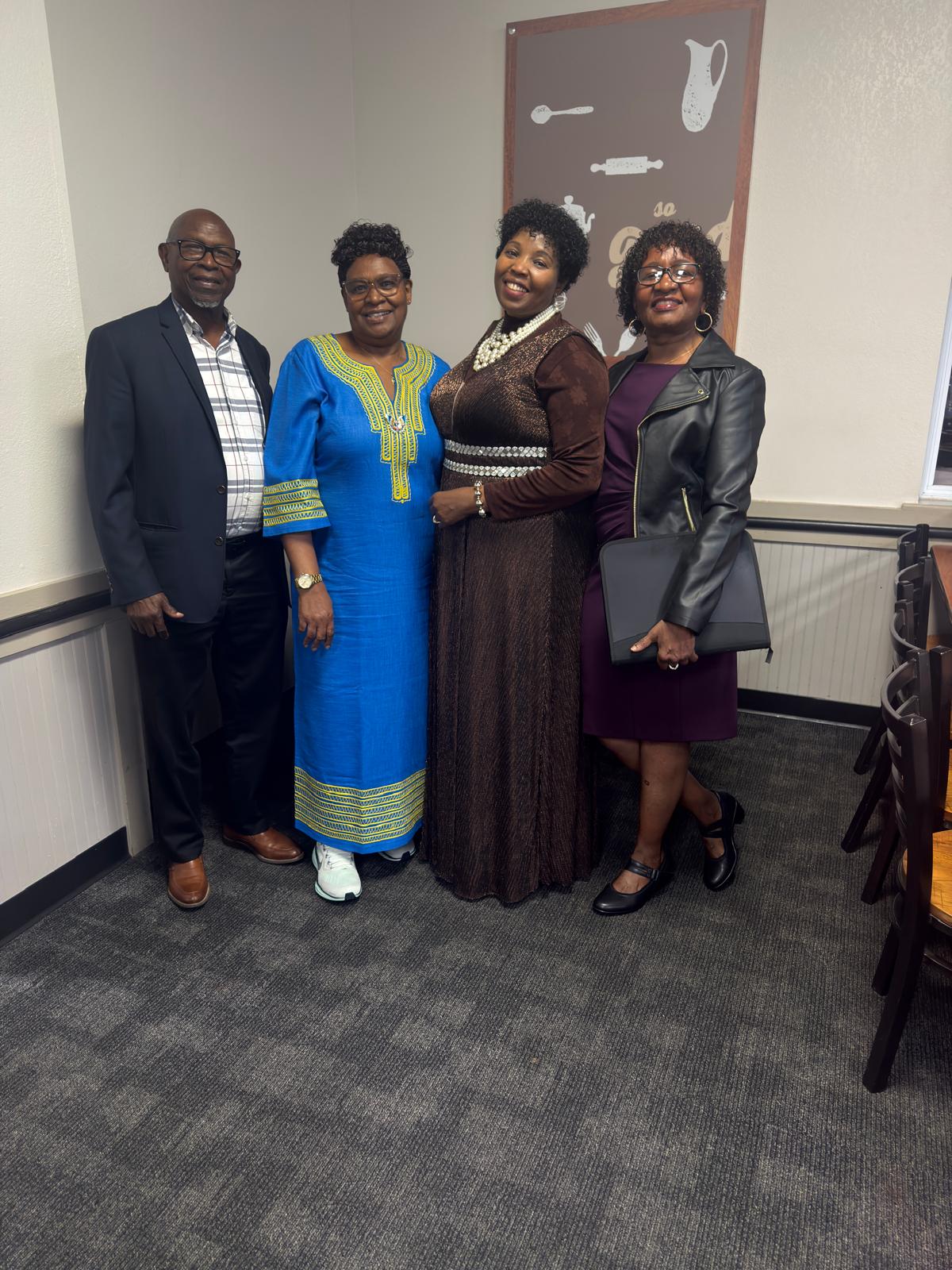 Four community friends standing together in a meeting space